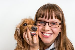 Woman and dog smiling to show healthy teeth.