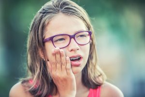 Girl holding her mouth due to braces problems