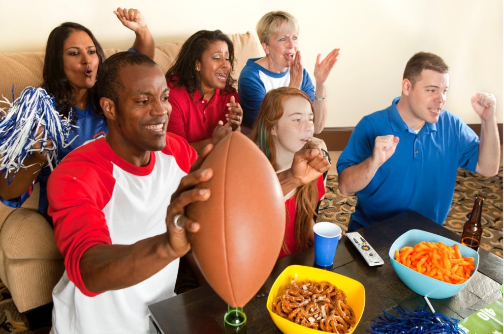 A group of people watching football on TV, 5 Delicious Braces Friendly Superbowl Snacks