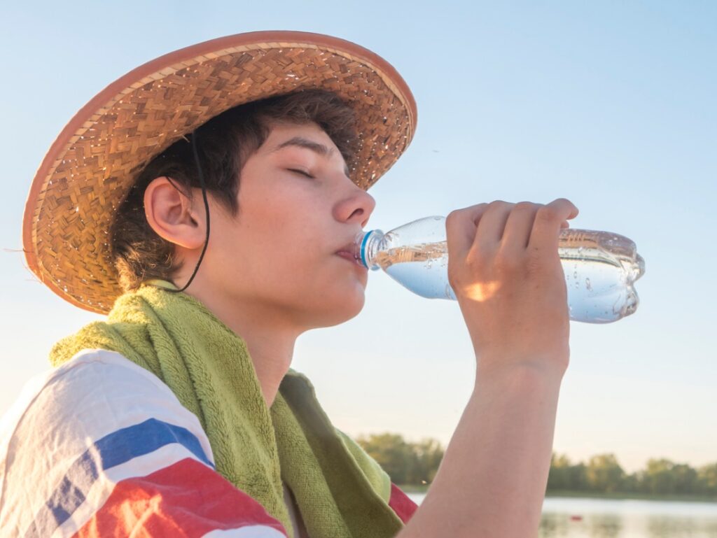 A person drinking from a bottle, Sun Safety for Your Braces