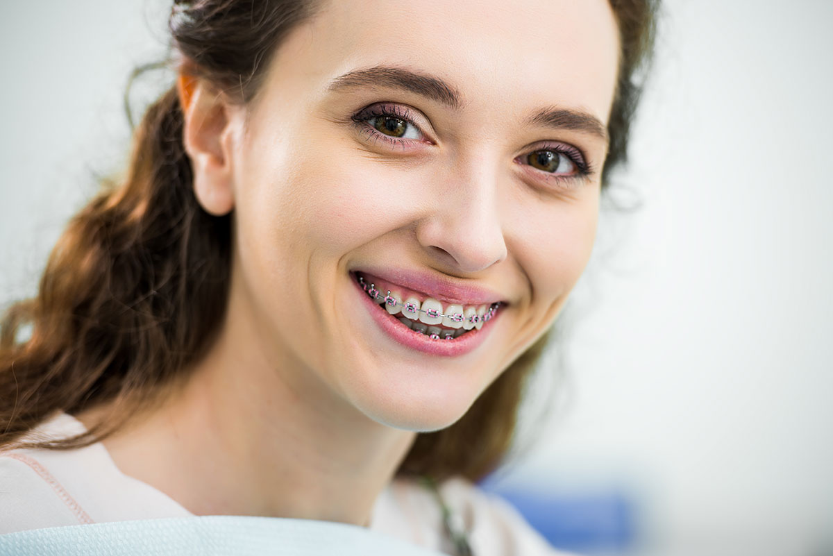 adult with braces smiling